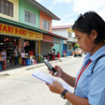 Field Researcher noting a nearby store as part of a census